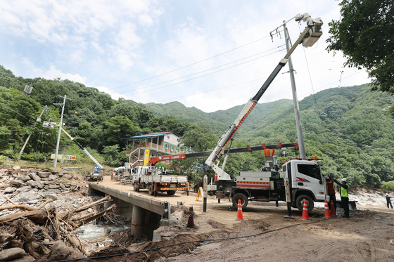 ２４日、京畿道加平郡（カピョングン）の集中豪雨で破損した電気施設を復旧する作業が行われている。　［写真　加平郡］