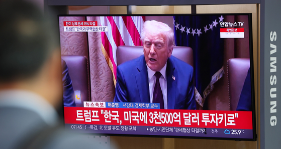 韓国と米国の関税交渉が妥結した３１日、ソウル駅の待合室で、ある市民が関連ニュースを視聴している。［写真　聯合ニュース］