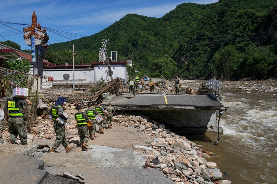 豪雨による被災地である中国・北京市郊外の密雲区に、３０日、救援物資が届けられている。［写真　ＡＰ＝聯合ニュース］