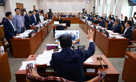 李春錫（イ・チュンソク）法制司法委員長が１日、国会法制司法委員会全体会議で民主党主導の挙手表決で「黄色い封筒法」などを通過させた後、国民の力議員（左側）が立ち上がって抗議している。　［ニュース１］