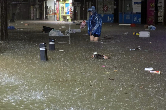 浸水した街を移動する市民。［写真　ニュース１、読者提供］