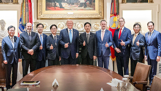 先月３０日（現地時間）、米ホワイトハウスで関税交渉が妥結した後、団体記念写真を撮影するトランプ大統領と韓国政府貿易交渉団。今後、米国が安保問題をめぐり韓国に圧力を加える可能性が高まった。　［写真　Ｘ］