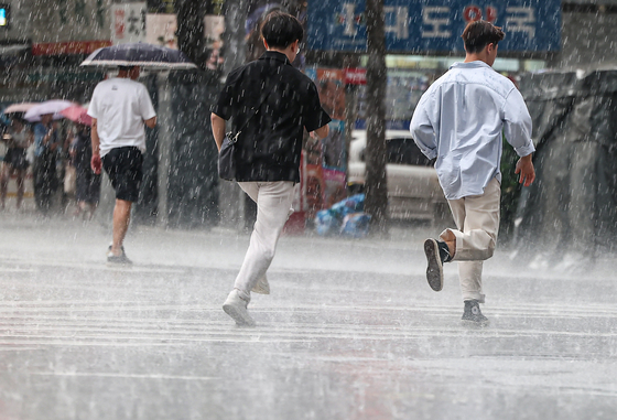 先月８日午後、ソウル鍾路区鐘閣（チョンノグ・チョンガク）駅近くで傘をさした市民たちが足を速めている。［写真　ニュース１］