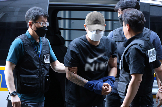 ５日午前、大田（テジョン）で交際のもつれによる殺人事件の２０代容疑者が、入院していた病院から退院後に警察に逮捕され、大田西部警察署に連行されている。［写真　聯合ニュース］