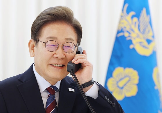 韓国の李在明（イ・ジェミョン）大統領が６月６日、ソウル竜山区漢南洞（ヨンサング・ハンナムドン）官邸で米国のドナルド・トランプ大統領と電話会談を行うため受話器を手に取っている。［写真　聯合ニュース］