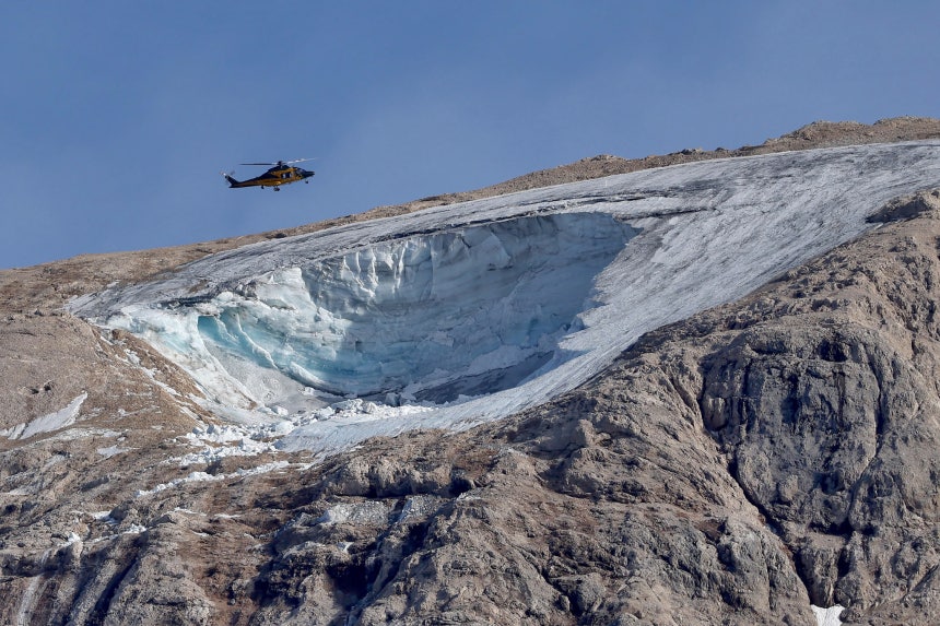 ２０２２年７月４日（現地時間）、イタリア・ドロミーティ山脈のカナツェイのマルモラーダ山で、当時発生した雪崩の現場上空をヘリコプターが飛行している。［写真　ＥＰＡ＝聯合ニュース］