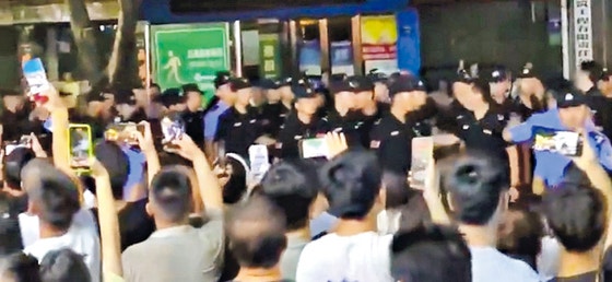 ７月２２日に中国四川省江油市で発生した１０代少女いじめ事件の不公平処理に不満を抱いたデモ隊が、８月４日、政府庁舎前の道路で警察と対峙している。［ＹｏｕＴｕｂｅ　キャプチャー］