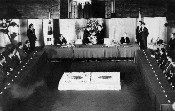 １９６５年６月２２日、日本の首相官邸で行われた韓日協定調印式で、両国の外相は韓日基本条約など２９件の関係文書に署名した。［中央フォト］