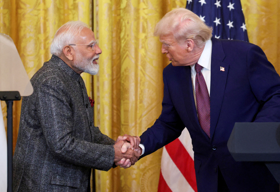 ナレンドラ・モディ印首相と握手を交わすトランプ大統領。［写真　ロイター＝聯合ニュース］