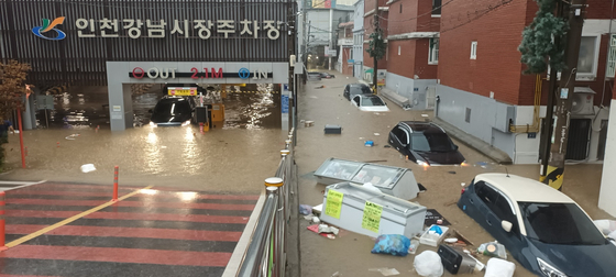 １３日、韓国首都圏の集中豪雨で冠水した仁川のある市場駐車場とその周辺の様子。［写真　ニュース１］
