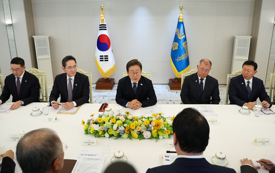 韓国の李在明（イ・ジェミョン）大統領が６月１３日、ソウル竜山（ヨンサン）大統領室で開かれた６経済団体・企業人懇談会で発言している。左からＬＧグループの具光謨（ク・グァンモ）会長、サムスン電子の李在鎔（イ・ジェヨン）会長、李大統領、現代自動車グループの鄭義宣（チョン・ウィソン）会長、ロッテグループの辛東彬（シン・ドンビン）会長。大統領室通信写真記者団