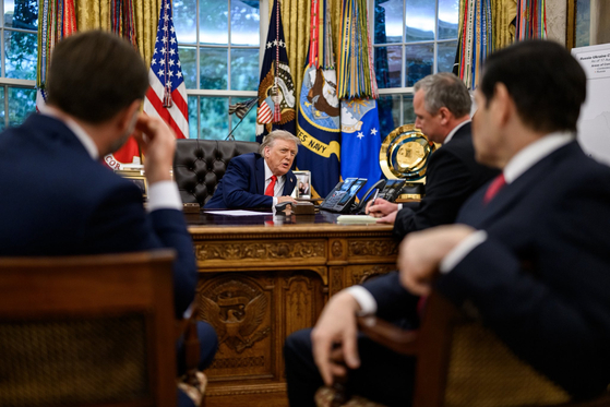 トランプ米大統領が１８日（現地時間）、ホワイトハウスのオーバルオフィスで欧州首脳らとウクライナの安全保障案について議論する途中、ロシアのプーチン大統領と電話をしている。　［写真　ホワイトハウス Ｘ］