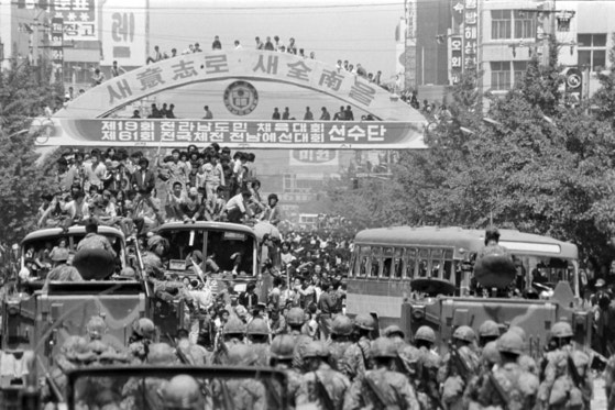１９８０年５月２１日、光州（クァンジュ）の全羅南道（チョルラナムド）庁前の錦南路（クムナムノ）で、戒厳令撤廃、全斗煥（チョン・ドゥファン）退陣など民主化を要求する市民たちがバスなどの上に乗って戒厳軍と対峙している。［写真　聯合ニュース］