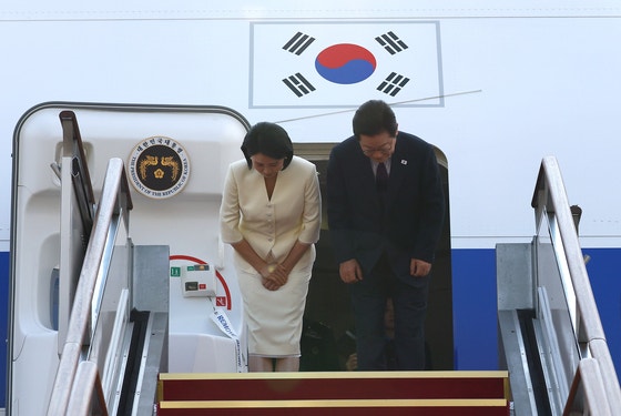 李在明（・ジェミョン）大統領と金恵景（キム・ヘギョン）夫人が２３日、京畿道城南市（ソンナムシ）ソウル空港で空軍１号機に搭乗する前、あいさつしている。　大統領室写真記者団