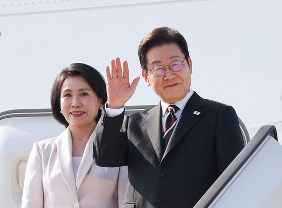 韓日首脳会談を終えた李在明大統領と金恵景夫人が２４日に東京の羽田空港からトランプ米大統領との首脳会談に向けワシントンＤＣへ向かって専用機に搭乗しながらあいさつしている。［写真　聯合ニュース］