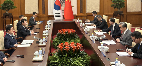 韓国の朴炳錫（パク・ビョンソク）元国会議長（左）を団長とする中国特使団が韓中修交３３周年となる２４日、北京の釣魚台国賓館で中国共産党中央政治局員兼外交部長の王毅氏と会談している。［写真　韓国外交部］
