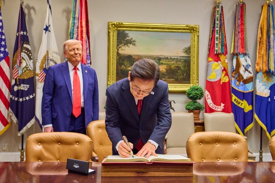 韓国の李在明（イ・ジェミョン）大統領が２５日（現地時間）、ワシントンＤ．Ｃ．ホワイトハウスで芳名録を記している。見守っていたトランプ大統領がペンに関心を示すと、李大統領がその場でこれをプレセントした。［写真　大統領室写真記者団］