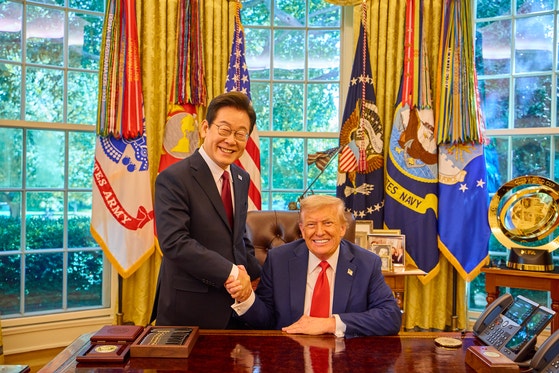 李在明大統領が２５日にホワイトハウスで開かれた韓米首脳会談後にトランプ米大統領と握手して笑みを浮かべている。［写真　聯合ニュース］