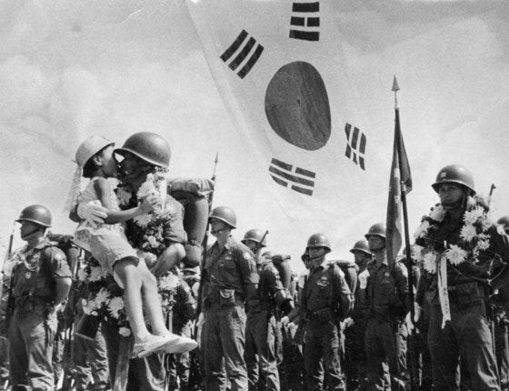  １９６６年９月、ベトナムに向かう猛虎部隊の歓送式がソウル空港で開かれた。ある将兵の娘が父親にキスをしている。［中央フォト］