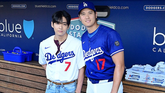   ＬＡドジャースのベンチで写真を撮影するＢＴＳのＶと大谷　［写真　ＡＰ＝聯合ニュース］