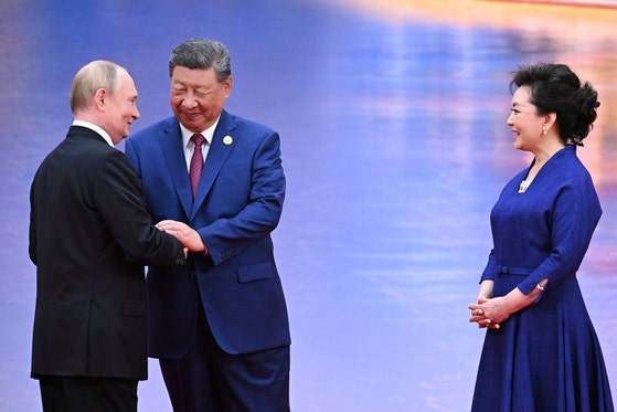 8月31日、上海協力機構(SCO)公式歓迎式で、ロシアのウラジーミル・プーチン大統領(左)と中国の習近平国家主席(中央)が手を取り合っている。右は習主席の妻、彭麗媛夫人。[写真 AP=聯合ニュース]