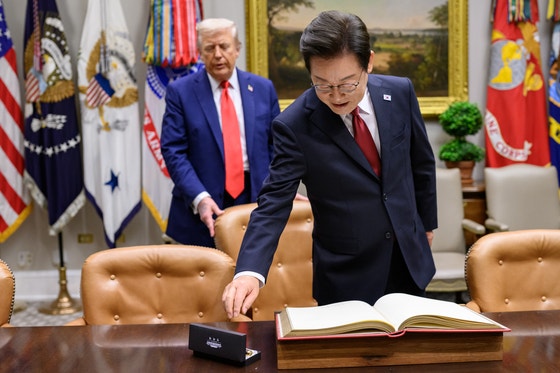先月25日（現地時間）、李在明（イ・ジェミョン）大統領が韓米首脳会談に先立ち米ホワイトハウスのルーズベルトルームで芳名録に署名するためペンを手に取っている。 ［写真 ホワイトハウス］