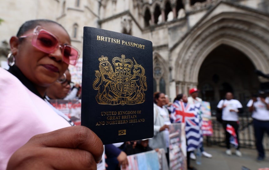 英国のパスポートを見せるデモ参加者 ［EPA＝聯合ニュース］