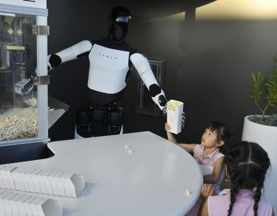 ロボット「オプティマス」が子どもにポップコーンを手渡す様子。［写真 UPI＝聯合ニュース］