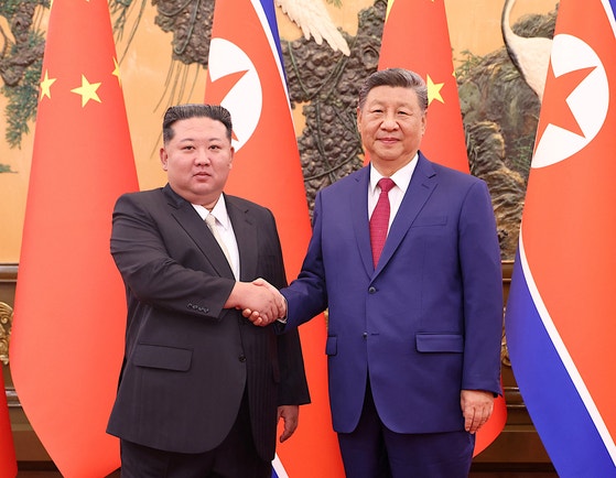 4日午後、中国北京人民大会堂で首脳会談の前に握手する北朝鮮の金正恩（キム・ジョンウン）国務委員長と中国の習近平国家主席。朝中首脳会談は2019年1月の金委員長の訪中、同年6月の習主席の訪朝以来およそ6年ぶりに行われた。 ［ロイター＝聯合ニュース］