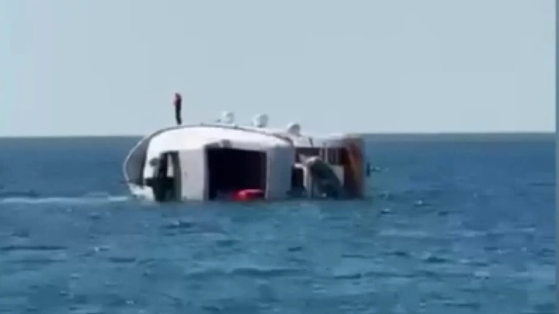 ヨットが転覆するとある男性が脱出するため船の上に立っている。［フォックスニュース キャプチャー］