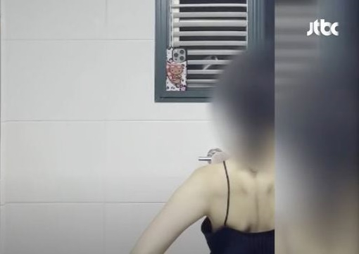   窓の外から女性を撮影する携帯電話の様子［JTBCキャプチャー］