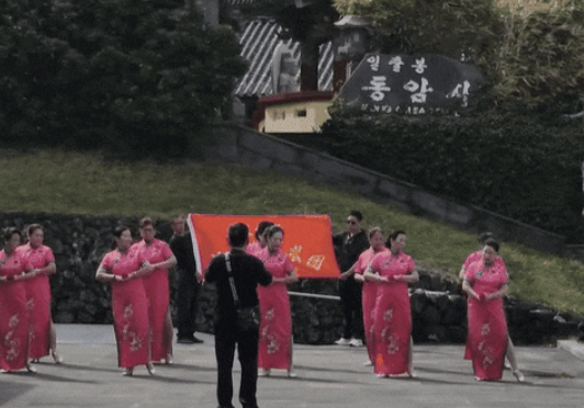   中国の伝統衣装を着た女性たちが集団で踊る様子。ソーシャルメディアキャプチャー