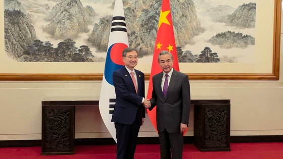 韓国外交部の趙顕長官（左）が17日午後、中国・北京の釣魚台国賓館で中国の王毅外相と握手をしている。［写真 北京特派員共同取材団］