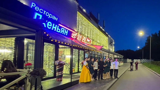 北朝鮮レストランのスタッフが店の前でポーズを取っている。［SNS キャプチャー］