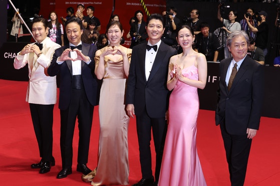 17日午後、釜山海雲台区（ヘウンデグ）映画の殿堂で開かれた第30回釜山国際映画祭（BIFF）の開幕式レッドカーペット行事で開幕作『仕方ない』の俳優と監督が写真撮影をしている。左からイ・ビョンホン、イ・ソンミン、ヨム・ヘラン、パク・ヒスン、ソン・イェジン、パク・チャヌク監督。 ［写真 聯合ニュース］