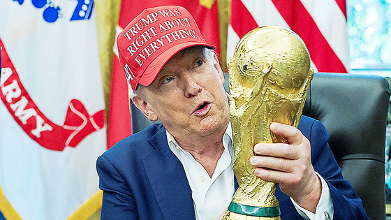 ドナルド・トランプ米国大統領が8月22日、ワシントンD．C．のホワイトハウス執務室で国際サッカー連盟（FIFA）ワールドカップ（W杯）のトロフィーを掲げている。［ロイター＝聯合ニュース］