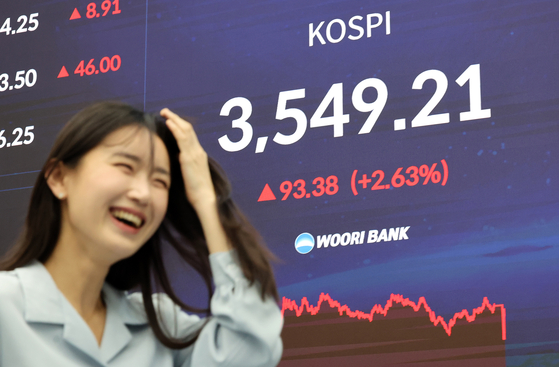 韓国総合株価指数（KOSPI）が史上初めて3500台を突破し、終値基準で過去最高値となる3549．21で取引を終えた2日午後、ソウル中区（チュング）のウリィ銀行ディーリングルームで関係者が業務を行っている。［写真 聯合ニュース］