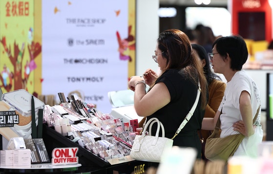 中国人団体観光客のノービザ入国が始まった先月29日、ソウル中区の新羅免税店ソウル店で中国人観光客が買い物をしている。 ［ニュース1］