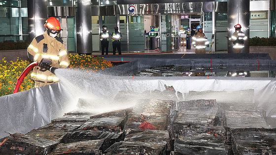 先月27日夜、大田儒城区の国家情報資源管理院火災現場で消火水槽に入れたリチウムイオンバッテリーに消防隊員が水をかけている。 ［聯合ニュース］