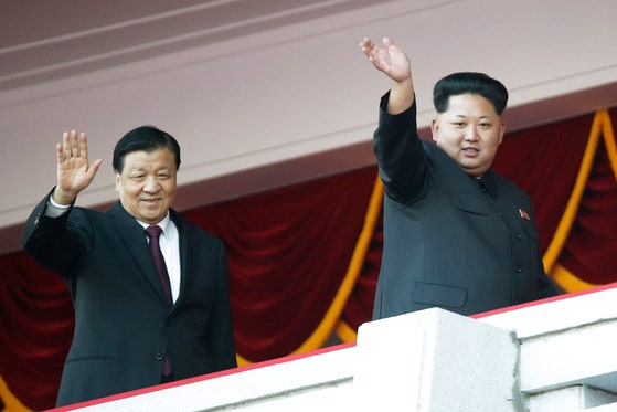 2015年10月10日、北朝鮮の金正恩（キム・ジョンウン）国務委員長（右）と中国共産党の劉雲山常務委員（左）が北朝鮮労働党創建記念閲兵式の壇上で手を振っている。［中央フォト］