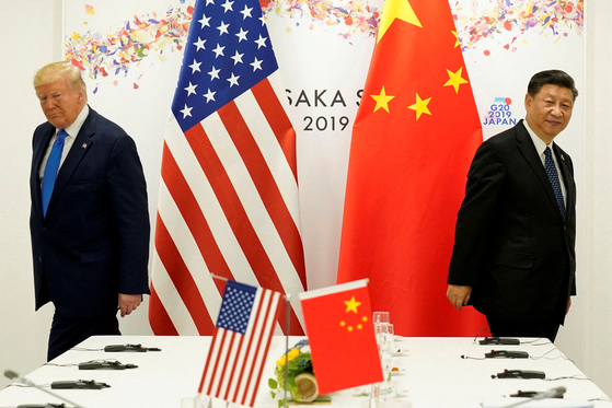 ドナルド・トランプ米国大統領（左）が2019年6月29日、大阪で開かれた主要20カ国・地域（G20）首脳会議で習近平中国国家主席との二者会談を終え、席を立っている。［写真 ロイター＝聯合ニュース］