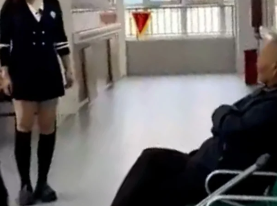   中国の介護施設で椅子に座る高齢者の前でダンスを踊る女性。［写真 SNS］