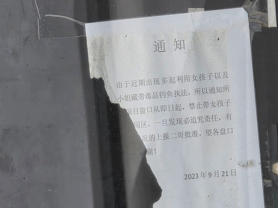 16日、カンボジア・プノンペン郊外センソック地区「サクラ団地」にあるウェンチの鉄門の内側に貼られた通知文。少女や女性を利用した麻薬密輸のおとり捜査が多発しているため、ウェンチに少女を連れてくることを禁止するという内容。プノンペン＝イ・ヨングン記者。