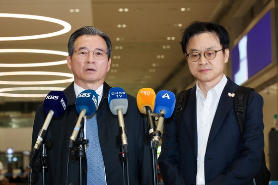 韓国の金容範（キム・ヨンボム）大統領室政策室長（左）と金正官（キム・ジョングァン）産業通商部長官が、韓米関税交渉の追加協議を終え、24日仁川（インチョン）国際空港を通じて帰国した後、取材陣の質問に答えている。［写真 聯合ニュース］