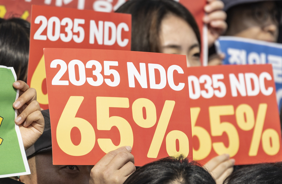 韓国政府が2035年の温室効果ガス縮小目標（2035NDC）を発表した6日、国会で気候危機非常行動が開催した市民集中行動で参加者が政府の中長期炭素縮小率65％水準設定を促すパフォーマンスをしている。［写真 聯合ニュース］