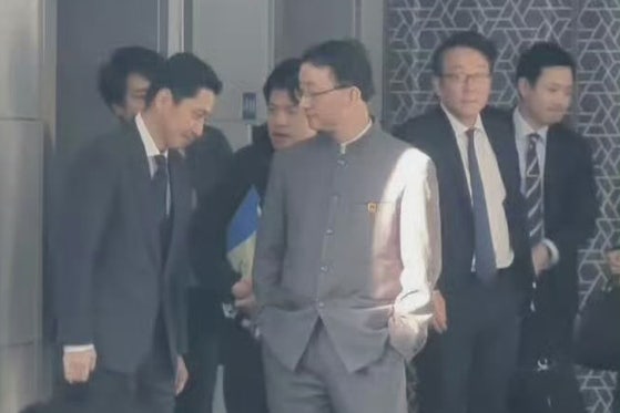 ポケットに手を入れたまま日本外務省の金井正彰アジア大洋州局長を見下ろすように立つ中国外交部の劉勁松アジア局長。［玉淵譚天　キャプチャー］