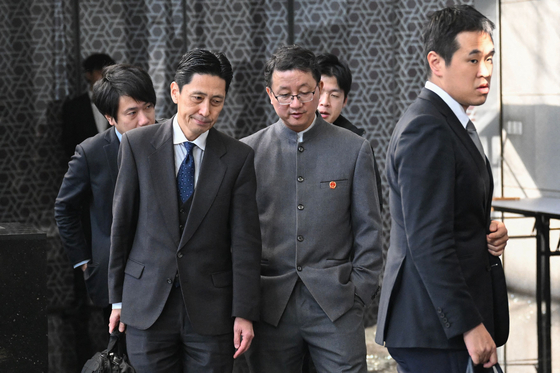 18日、中国外交部の劉勁松アジア局長（中央）と日本外務省の金井正彰アジア大洋州局長（左）が、中国・北京の外交部庁舎で協議を終え、深刻な表情で出てくる様子。［AFP＝聯合ニュース］