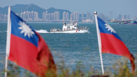 10月18日、台湾の金門島海域を台湾の警備艇がパトロールしている。後に中国厦門の建物が見える。［写真 ロイター］