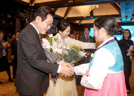 李在明（イ・ジェミョン）大統領と金恵景（キム・ヘギョン）夫人が20日（現地時間）、エジプト・カイロで開催された同胞懇談会で子どもから花束を受けている。 チョン・ミンギュ記者