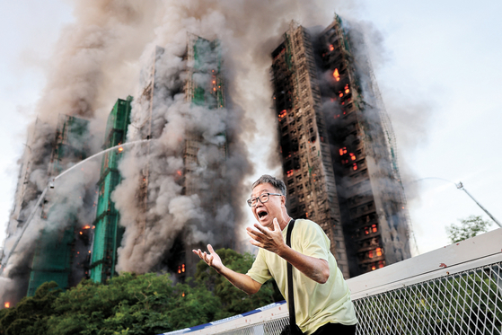 26日（現地時間）午後、香港北部の大埔地区にある高層住宅群で火災が発生し、一帯に赤い煙が広がっている。［ロイター＝聯合ニュース］